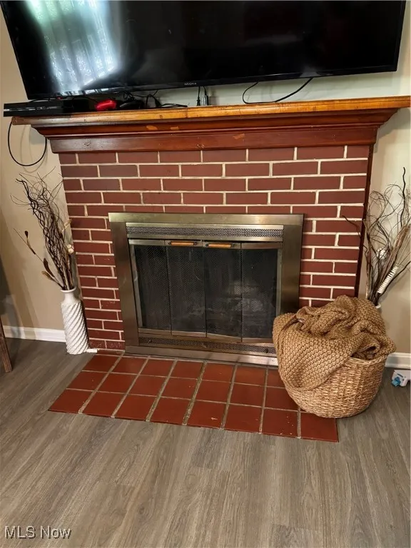 Detailed view of a fireplace and wood finished floors