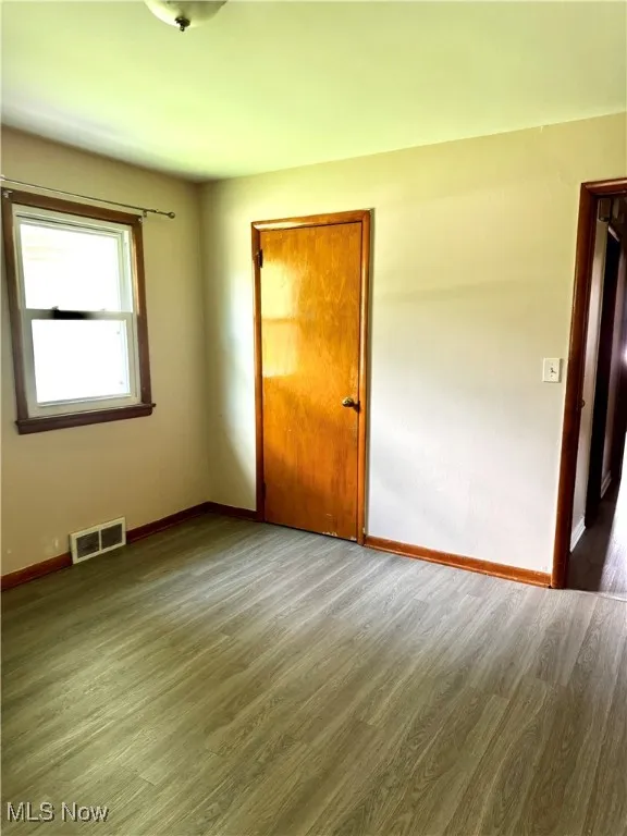 Spare room with baseboards and wood finished floors