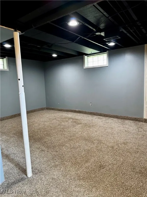 Basement featuring carpet and plenty of natural light