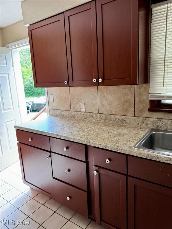 Kitchen with tasteful backsplash and light tile patterned flooring