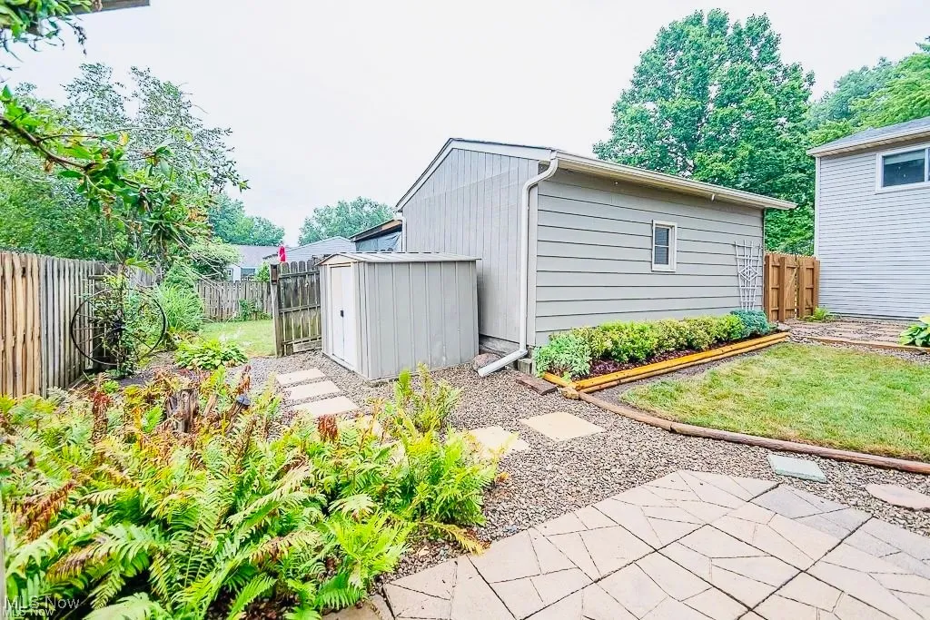 Fenced backyard with a storage shed and a patio