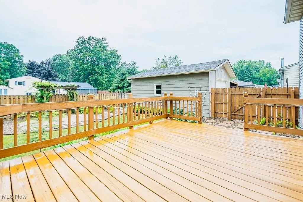 Wooden terrace with a fenced backyard