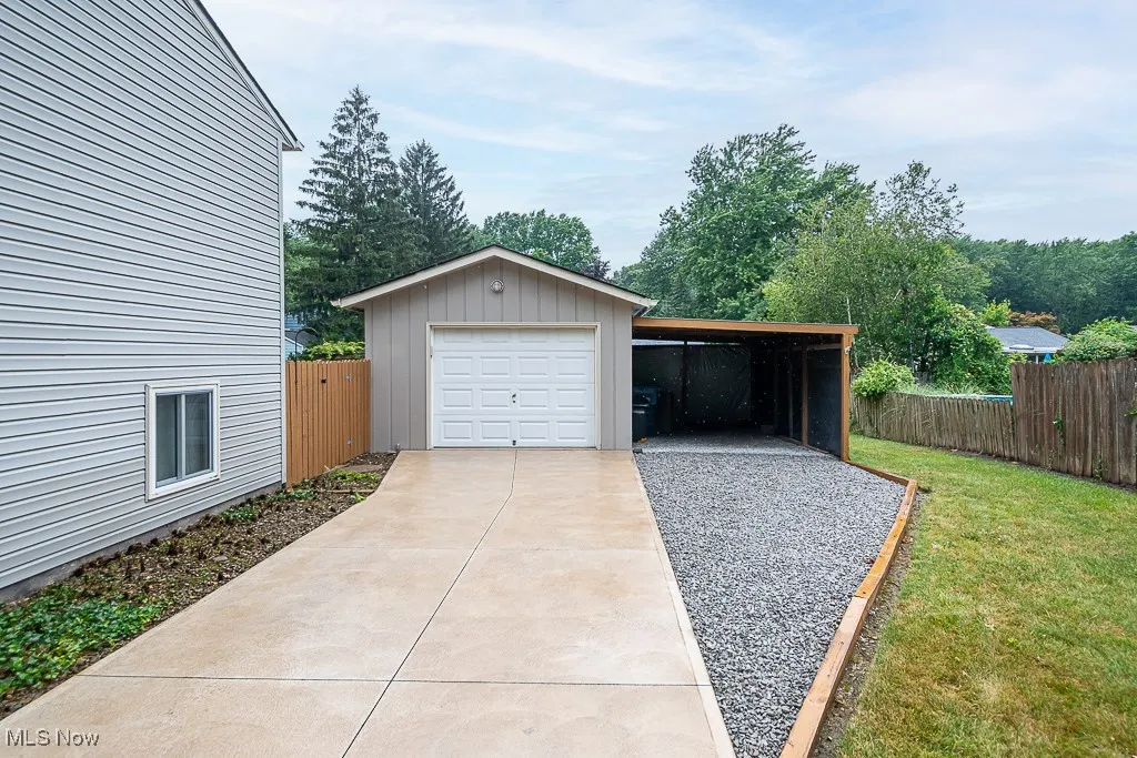 Garage featuring driveway a detached garage and carport