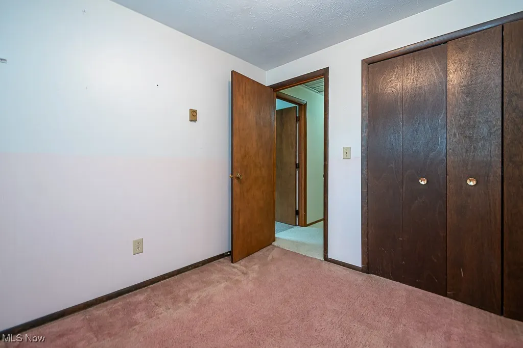 Unfurnished bedroom with carpet flooring and a closet