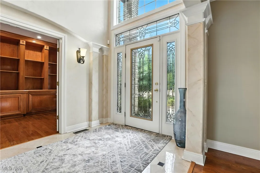 Foyer featuring ornate columns and baseboards
