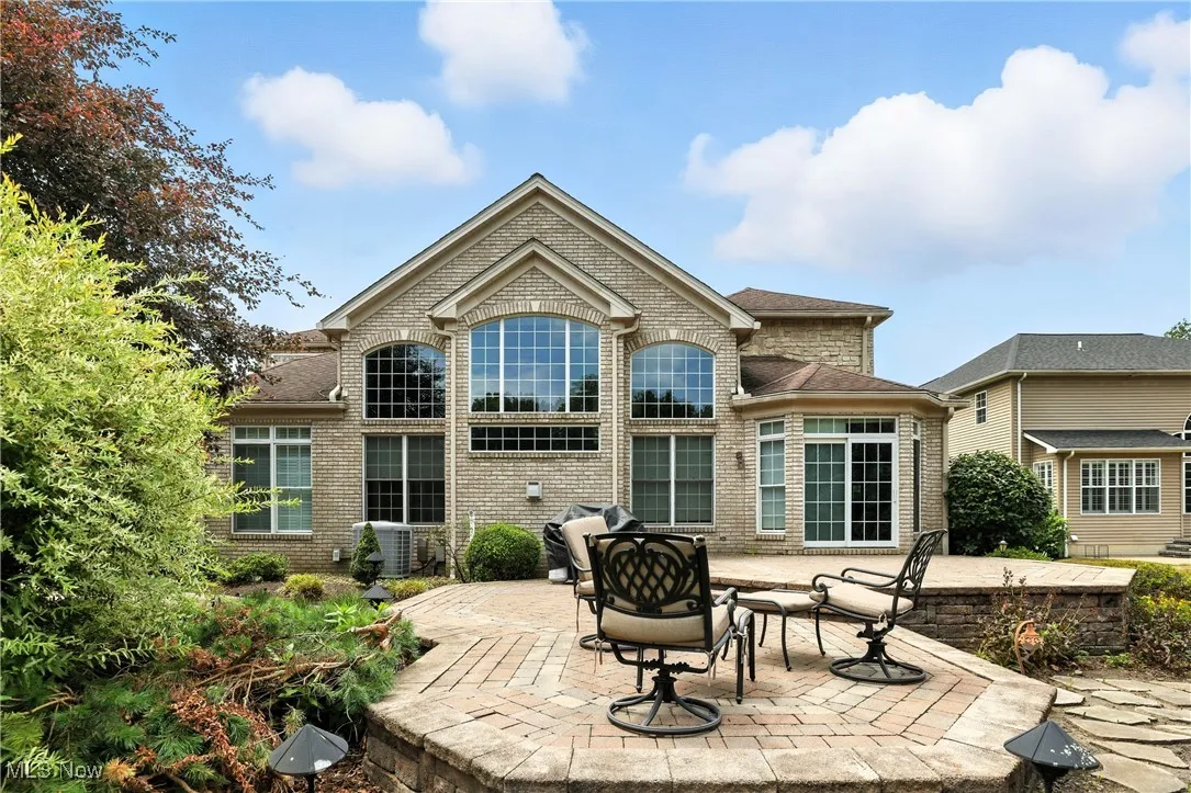 Rear view of house featuring a patio and brick siding