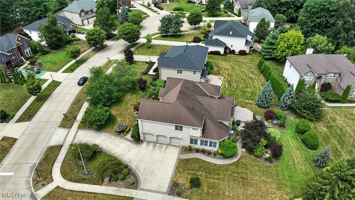 Aerial view of property and surrounding area featuring nearby suburban area