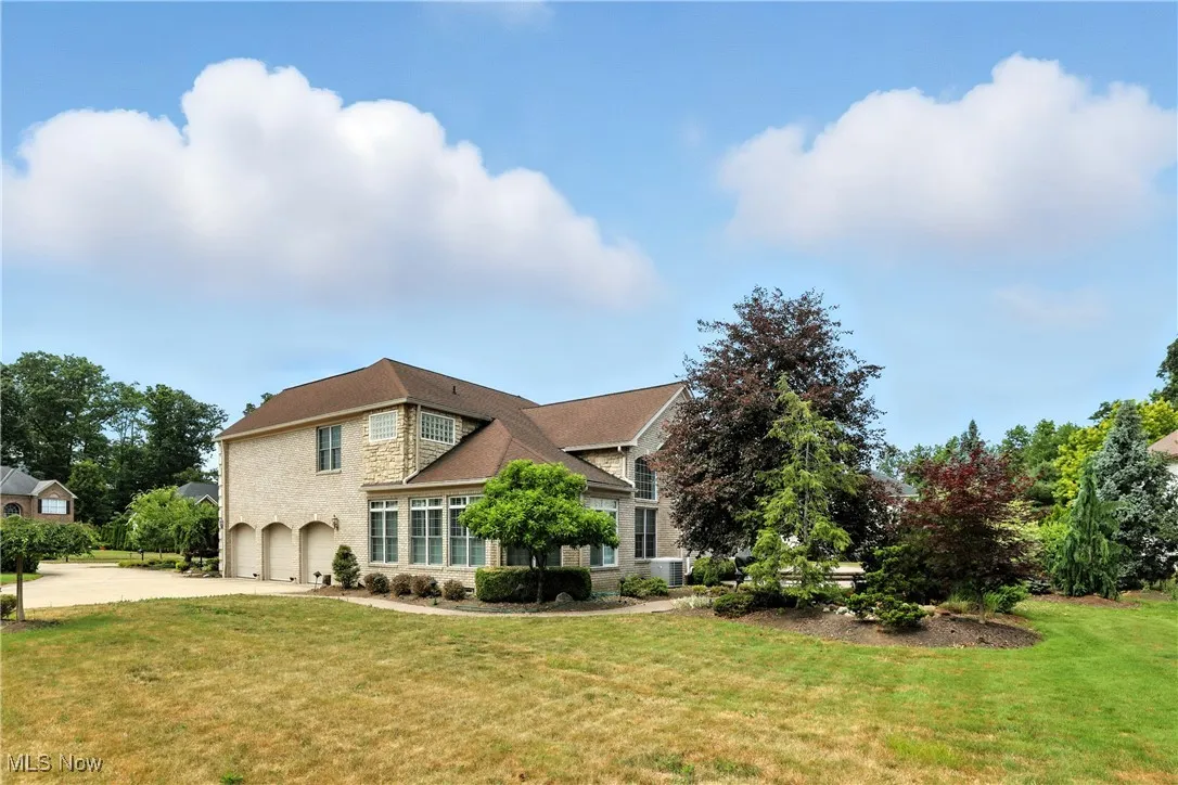 View of front of home with an attached garage, concrete driveway, and a front lawn