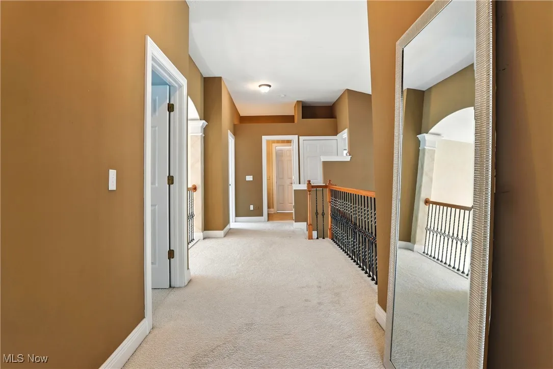 Corridor featuring carpet and baseboards