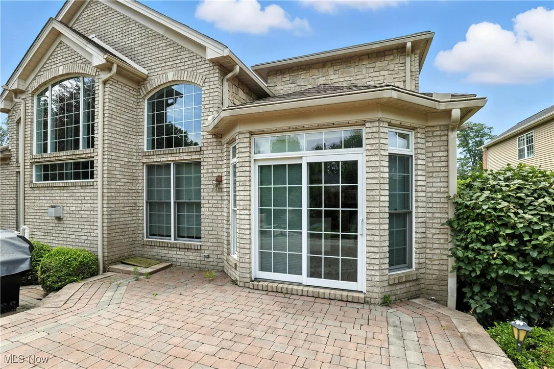 Back of property with a patio area and brick siding