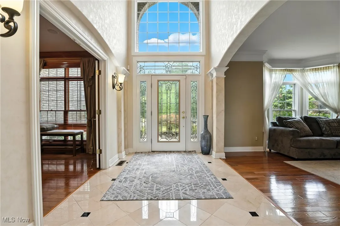 Entryway featuring arched walkways, ornamental molding, tile patterned flooring, and ornate columns