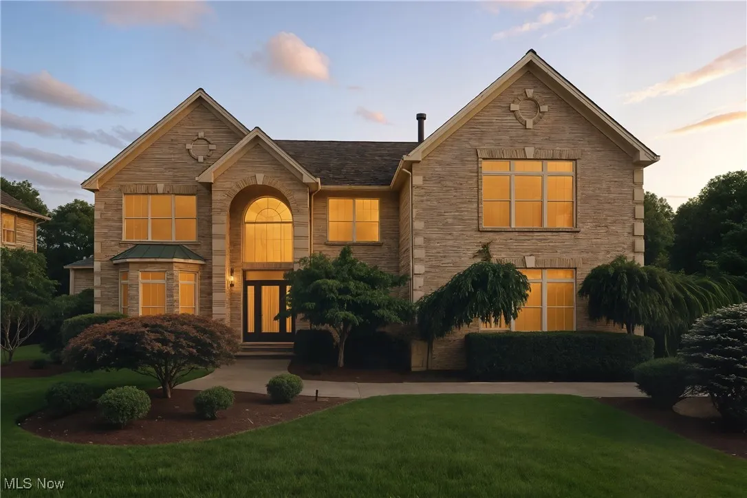 View of front facade with stone siding and a lawn