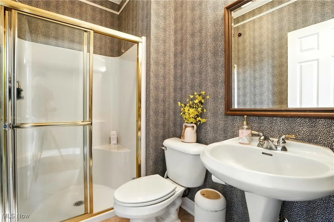 Bathroom featuring a shower stall and toilet