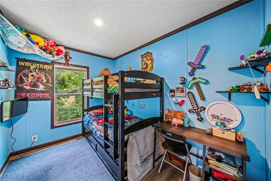 Bedroom with a textured ceiling, crown molding, and recessed lighting