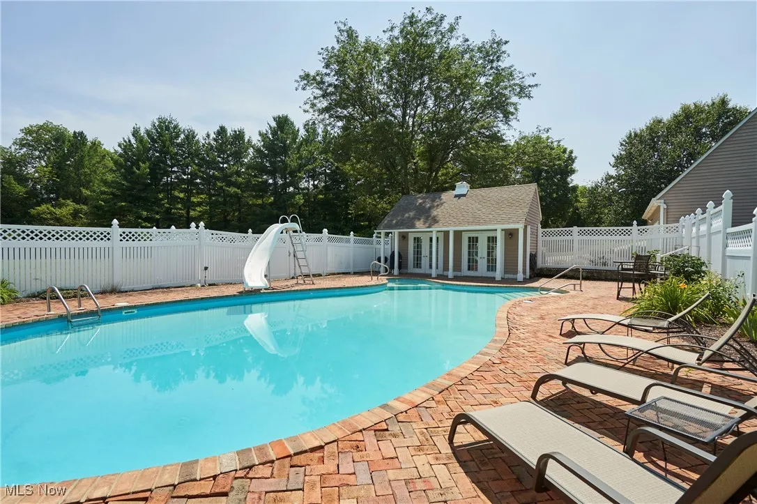 View of pool with slide and pool house.