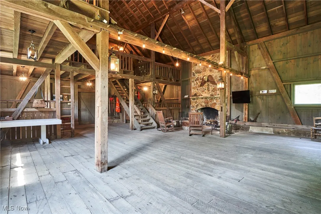 Timber barn featuring a stone fireplace and loft