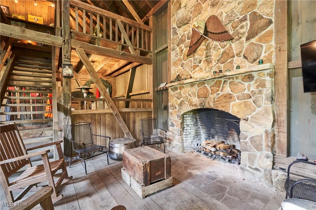 Barn featuring a stone fireplace and loft