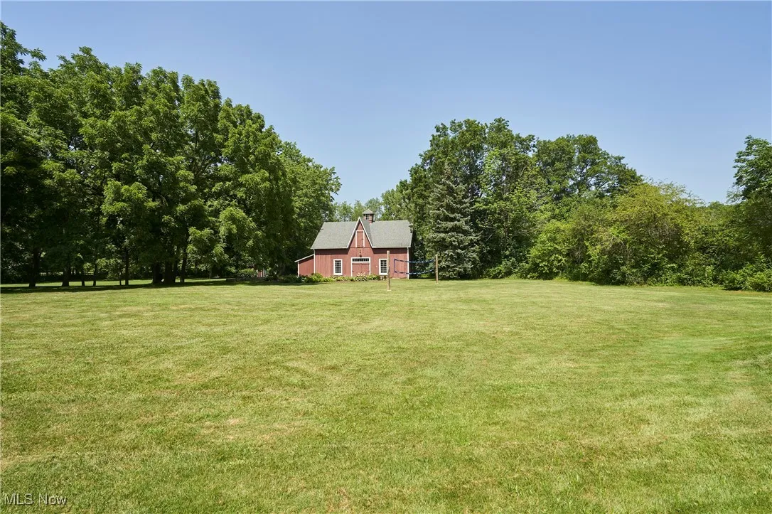 View of grassy yard featuring the barn