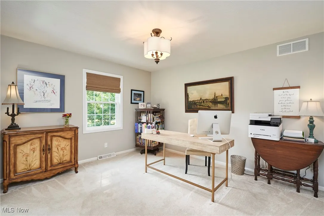 Home office featuring light colored carpet and baseboards