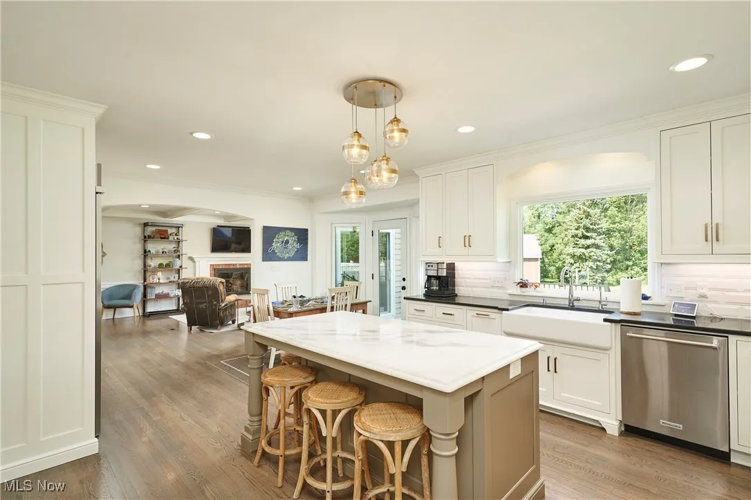 Kitchen featuring dishwasher, decorative backsplash, open floor plan, white cabinets, and recessed lighting
