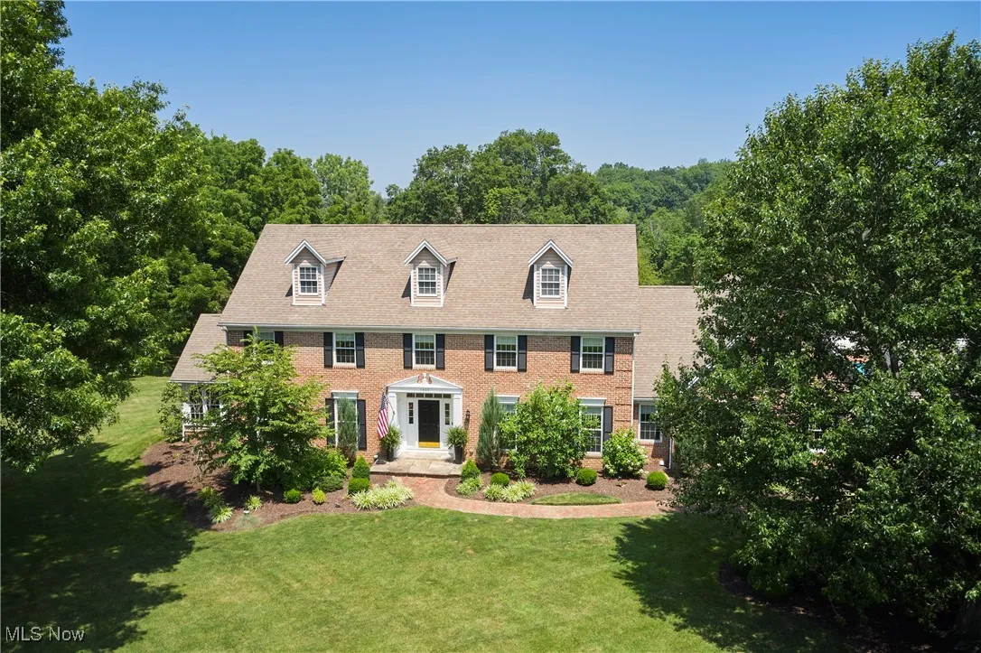 Colonial home with a front lawn and brick siding