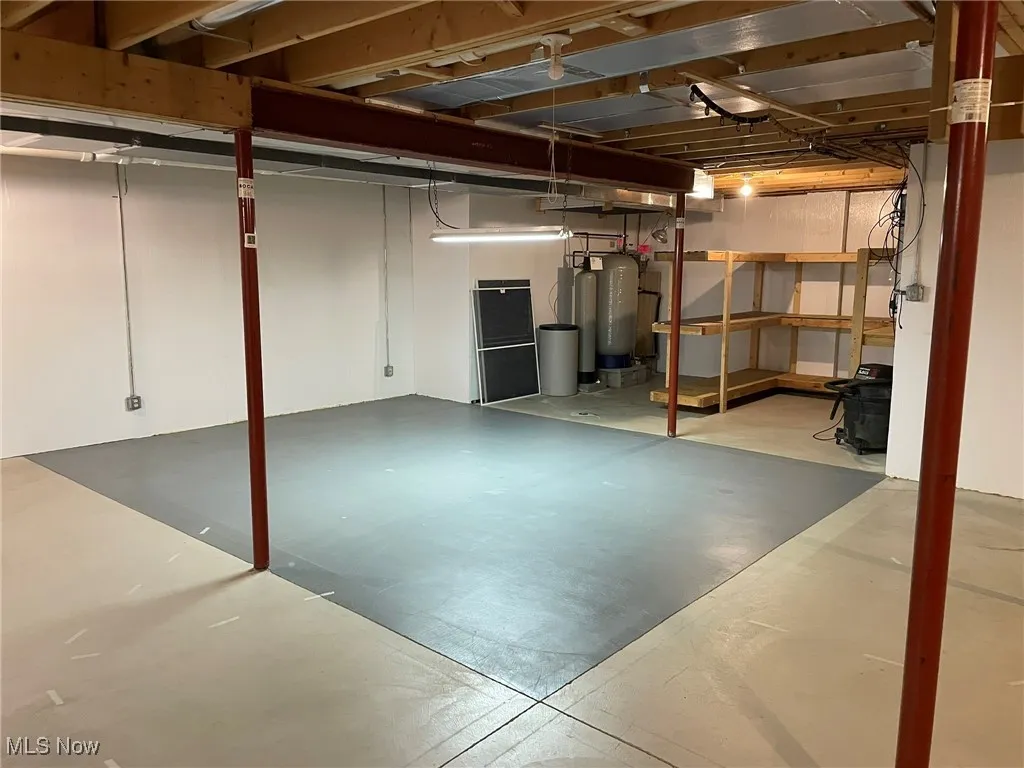 Unfinished basement with a water pressure tank and a water softener system