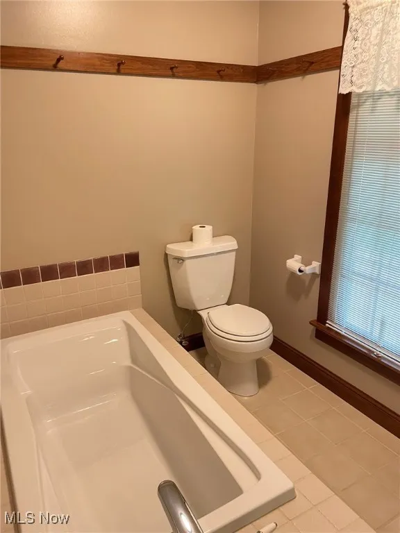 Bathroom featuring a bath and tile patterned flooring