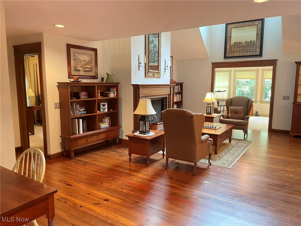 Living area featuring a brick fireplace, hardwood / wood-style flooring, and recessed lighting