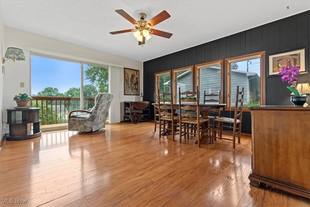 Dining area featuring a ceiling fan and laminate / wood-style floors.  The 3 back slider doors offer a beautiful view the sunrise each morning.