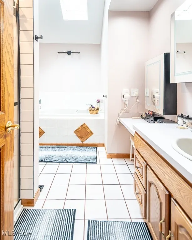 Full bath with vanity, a skylight, and a step-in shower