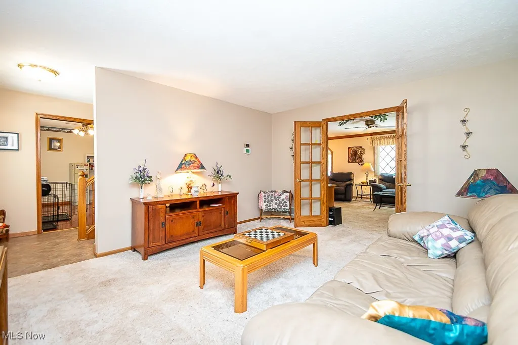 Living area with light carpet and french doors