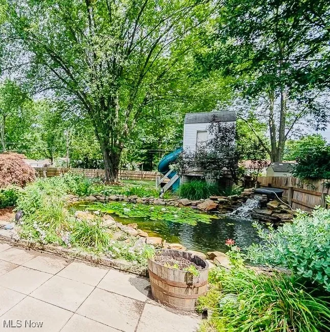 View of yard featuring a garden pond stocked with 40-50 koi fish