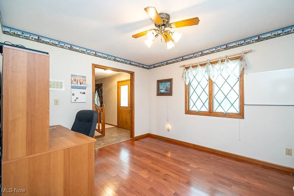 Office with hardwood floors and a ceiling fan