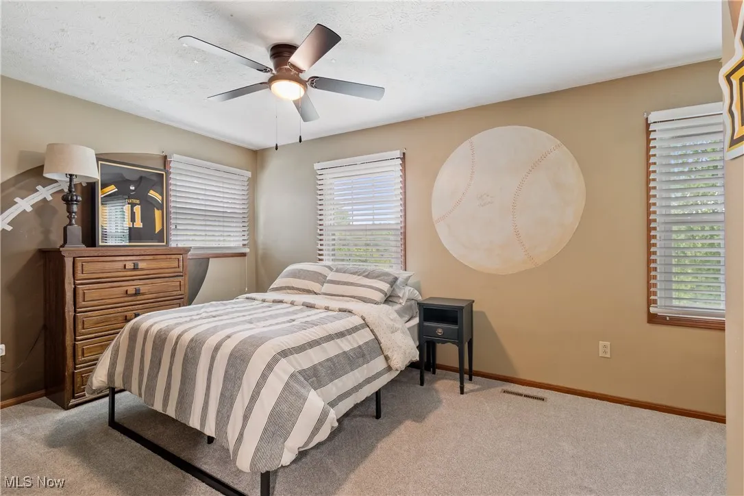 Bedroom featuring carpet, ceiling fan, and a textured ceiling