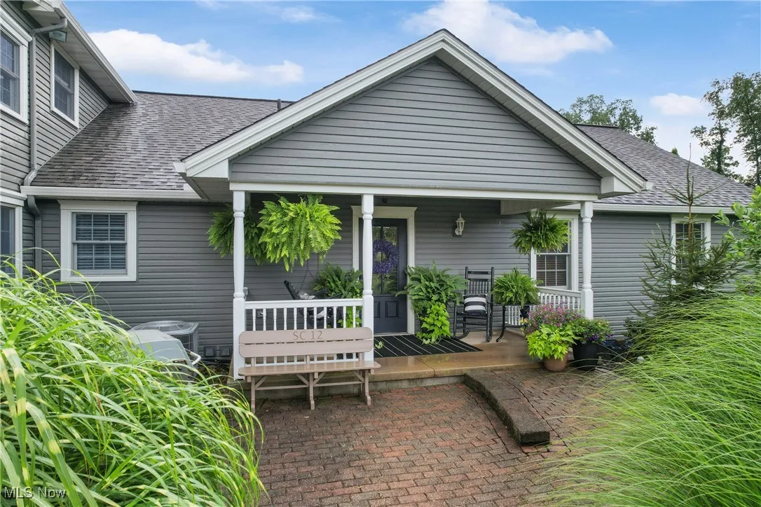 Rear view of house with a shingled roof and a porch