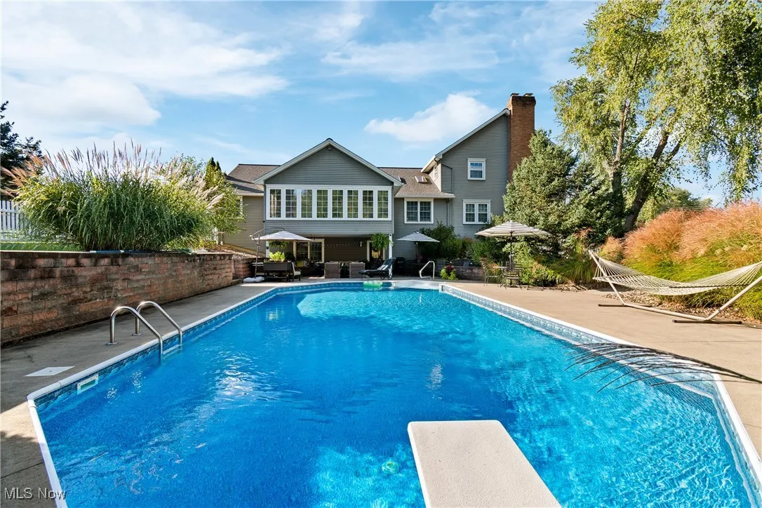 View of pool featuring a diving board and a patio