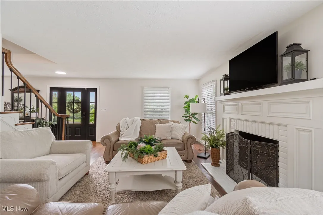 Living area featuring stairway, a fireplace, and light wood-type flooring