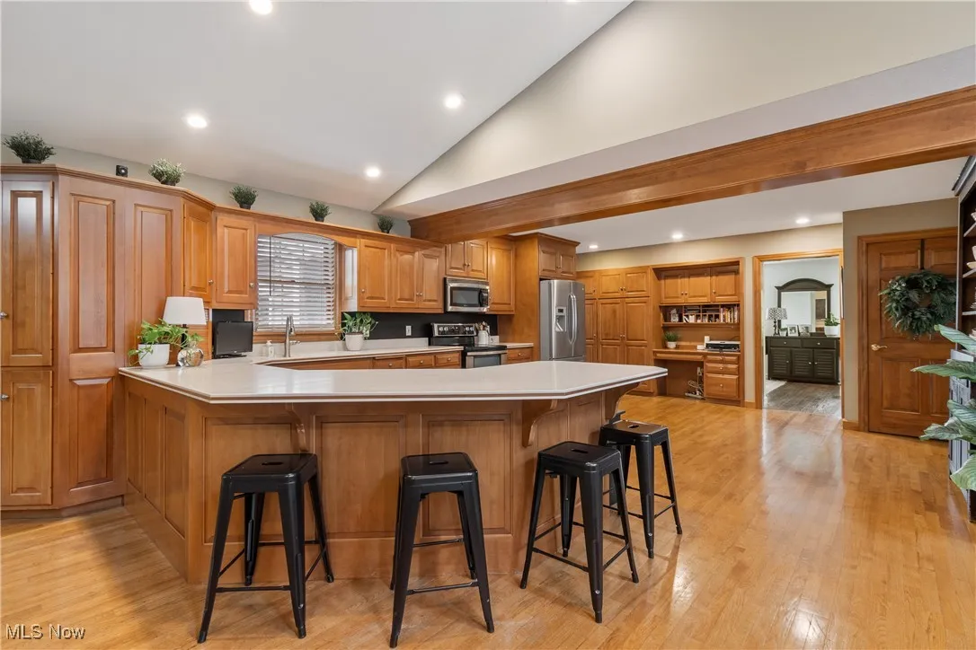 Kitchen with a peninsula, light countertops, a breakfast bar area, appliances with stainless steel finishes, and recessed lighting