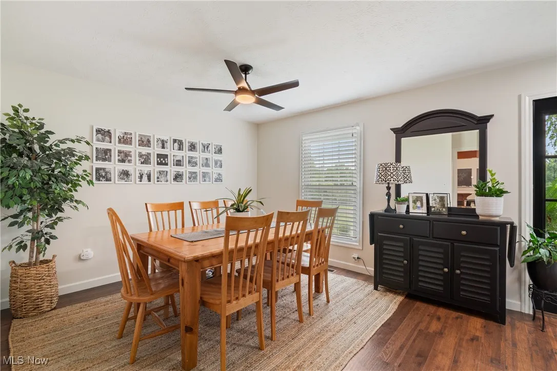 Dining area with healthy amount of natural light, dark wood finished floors, and ceiling fan