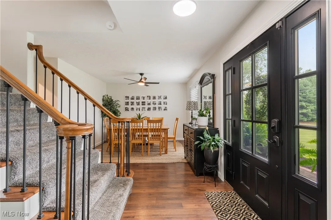 Entryway featuring stairs, dark wood-type flooring, and ceiling fan
