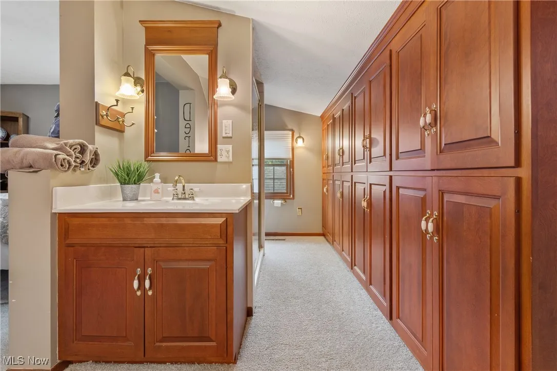 Bathroom with lofted ceiling and vanity