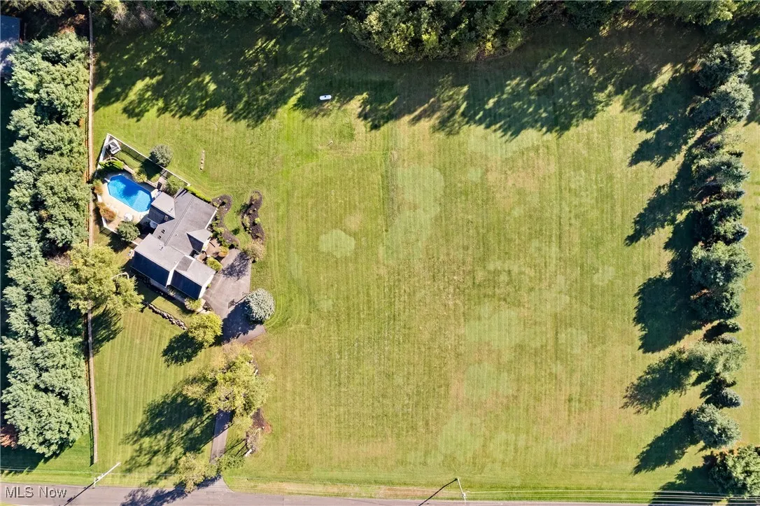 Aerial view of property and surrounding area featuring a pool area