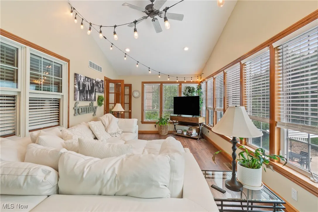 Living room with wood finished floors, a ceiling fan, recessed lighting, and high vaulted ceiling