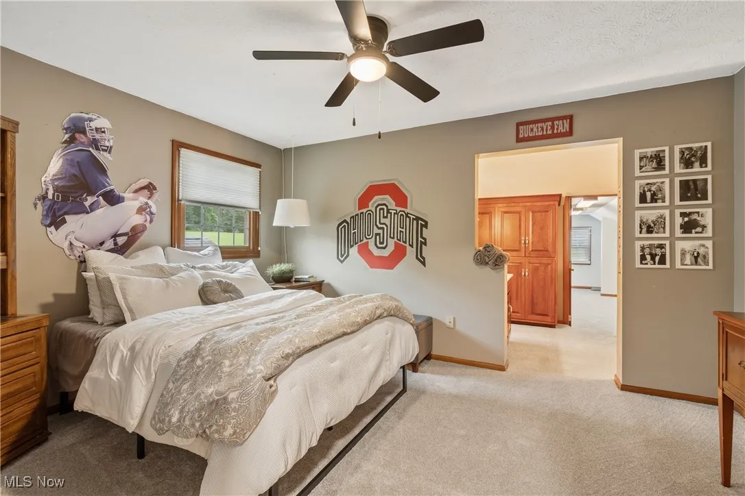 Bedroom with light carpet and a ceiling fan