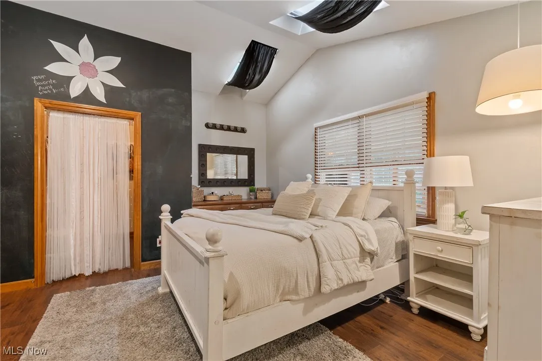 Bedroom with wood finished floors and lofted ceiling