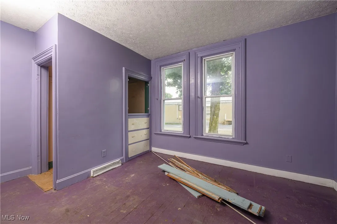Unfurnished bedroom with a textured ceiling and baseboards