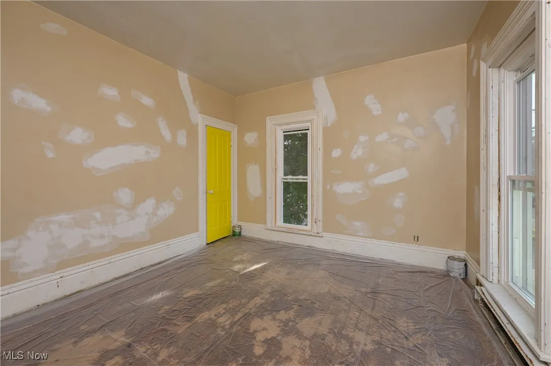 Unfurnished room with baseboards and a baseboard heating unit