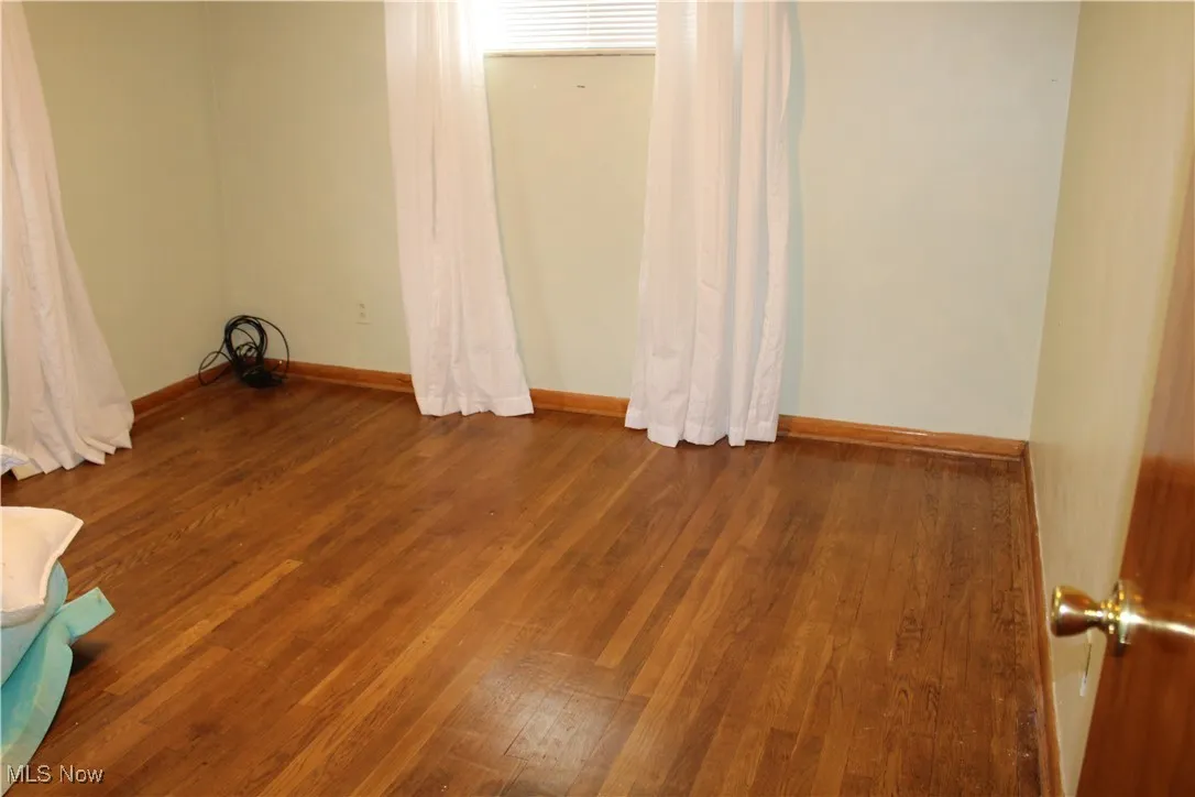 Spare room featuring wood finished floors and baseboards