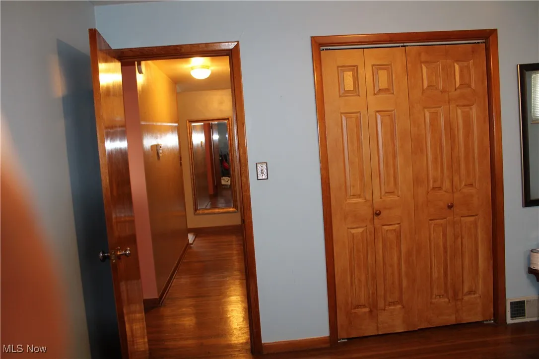 Corridor featuring dark wood-style floors