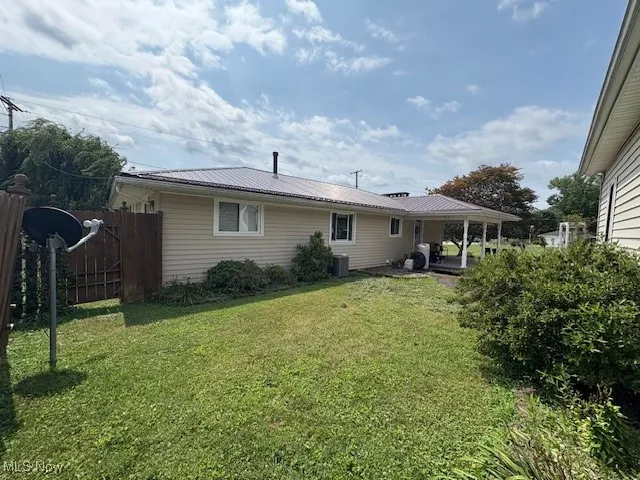 Rear view of property featuring a metal roof and a patio